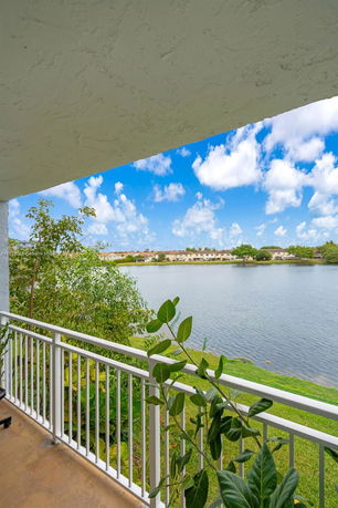 View of a lake and houses from a building balcony.