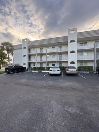 Front view of a three-story apartment building with balconies.