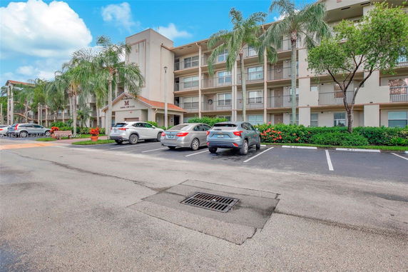 Front view of a multi-story building with a parking area.