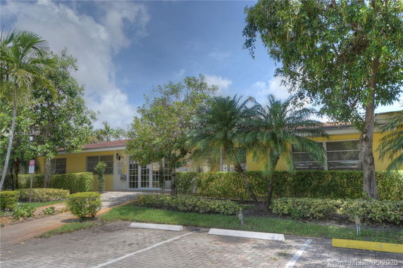 Front view of a single-story building with yellow walls and a red roof.