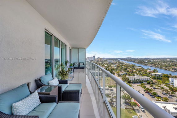 Balcony with outdoor seating offers a panoramic view of the city and waterway.