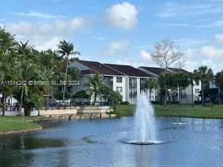 View of residential buildings near a pond with a fountain.