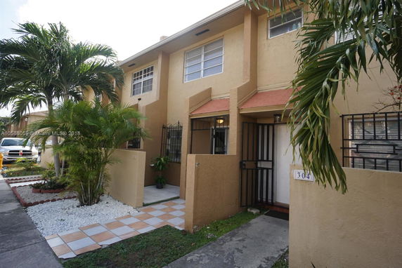 Front view of a two-story townhouse with a gated entrance.