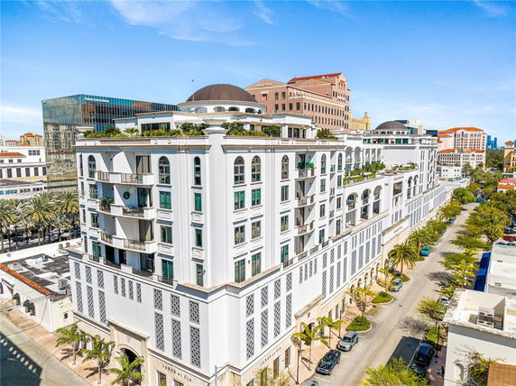 Front view of a multi-story building with balconies and a dome roof.