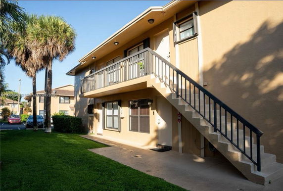 Front view of a two-story building with an exterior staircase.