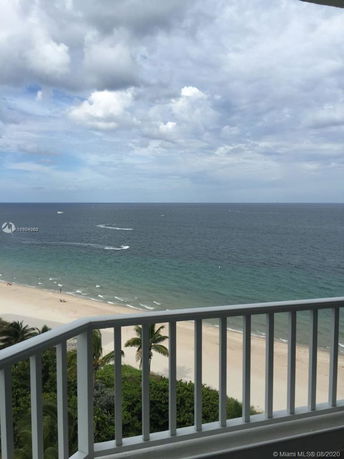 Panoramic view from a balcony overlooking the ocean and beach.