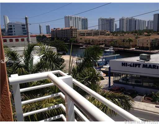 Panoramic view of surrounding buildings with a marina and greenery from a balcony.