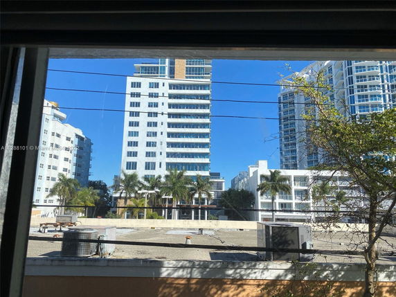 Multiple high-rise buildings with a rooftop visible in the foreground.