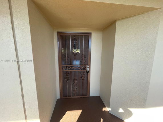 Front view of a house entrance with a decorative metal security door.