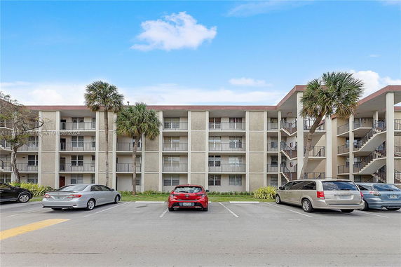 Front view of a multi-story apartment building with balconies and exterior staircases.