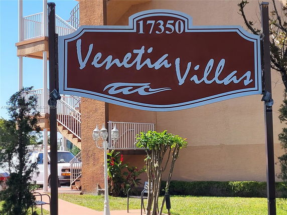 Signage for Venetia Villas with a view of building exterior and staircase.