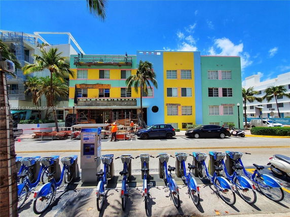 Front view of a colorful multi-story building with construction work in progress.