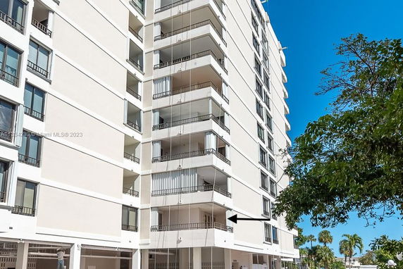 Front view of a multi-story apartment building with balconies.