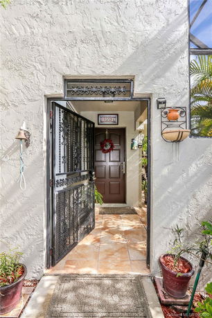 Entrance view of a house with a decorative wreath on the door and a welcome sign.