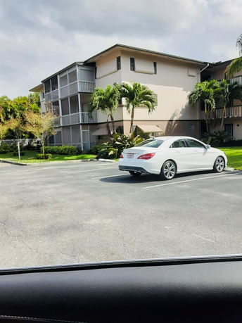Outdoor parking area in front of a multi-story residential building.
