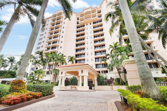 Front view of a multi-story residential building with balconies and an entrance canopy.