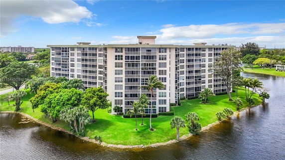 View of a multi-story apartment building situated by a water body.