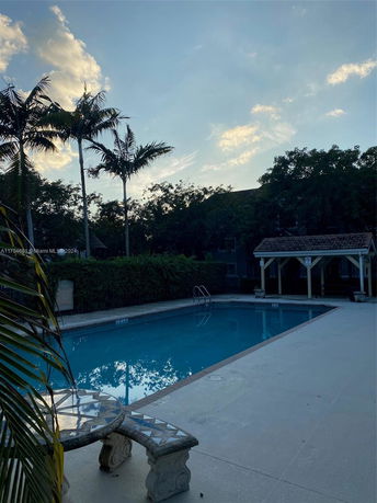 Outdoor swimming pool area with a decorative table and bench.