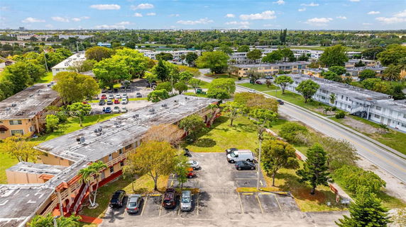 Aerial view of a residential area with multiple buildings and tree-lined streets.