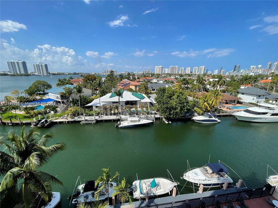 Panoramic view of a waterfront area with boats, canals, and city skyline in the background.