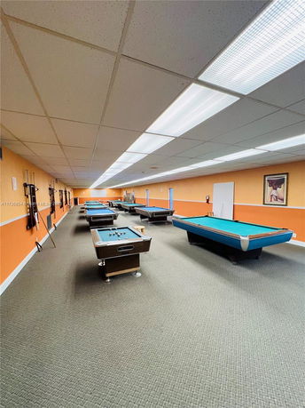 Room with multiple billiards tables and bright lighting.
