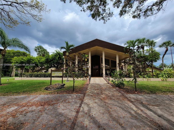 Front view of a large building with prominent columns and landscaped surroundings.
