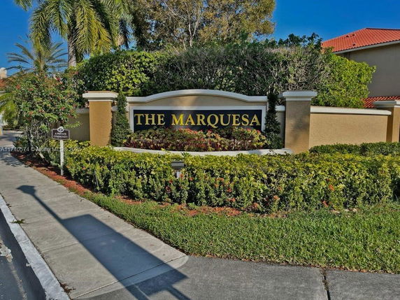 Entrance signage for a community named 'The Marquesa' with surrounding greenery.