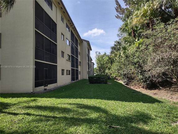 Side view of a multi-story building with screened balconies.