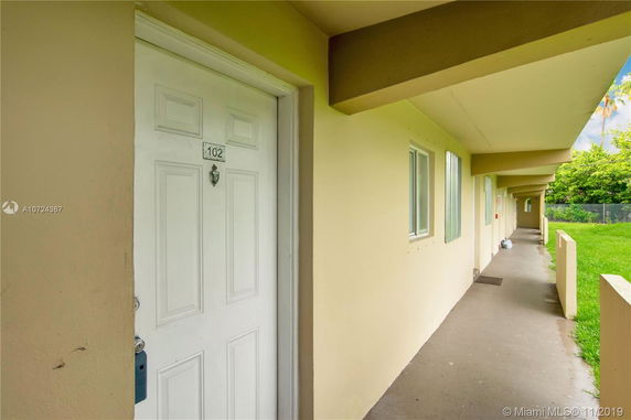 Outdoor hallway with apartment doors and windows.