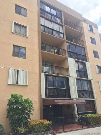 Front view of a multi-story residential building with balconies.