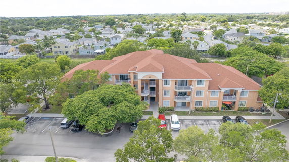 Front view of a multi-story apartment building with a red roof and balconies.