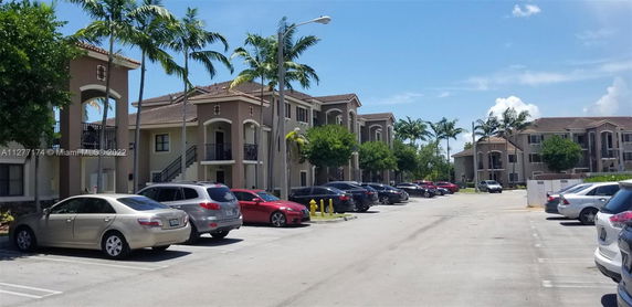 Outdoor parking area in front of apartment buildings.