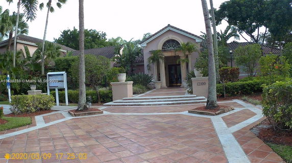 Front view of a house with a tiled entrance and landscaping.
