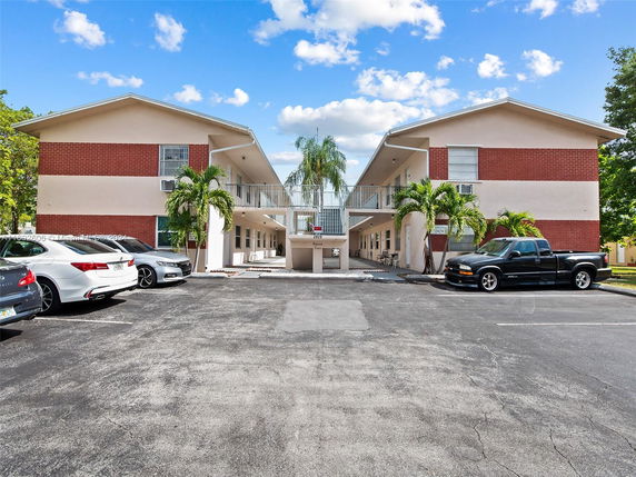 Outdoor parking area in front of a two-story apartment building.
