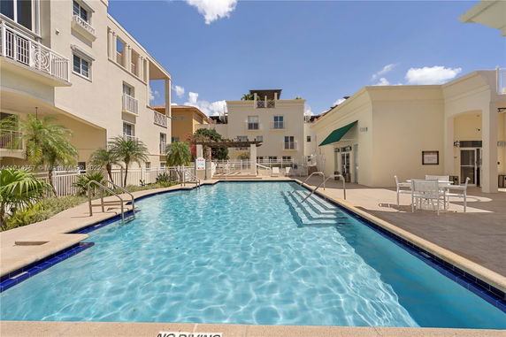 Outdoor swimming pool area with adjacent buildings.