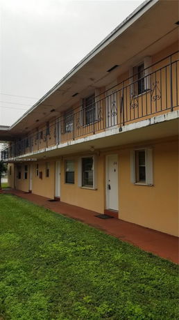 Front view of a two-story building with exterior corridors and railing.