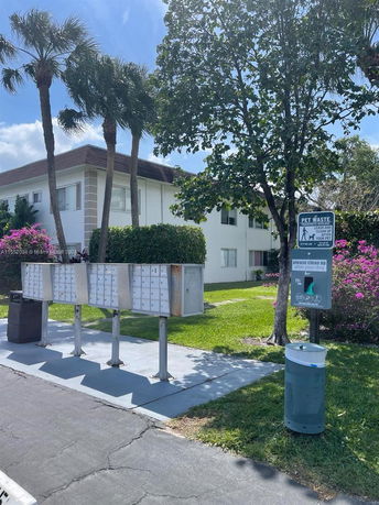 Front view of a two-story building with a flat roof and multiple mailboxes in front.