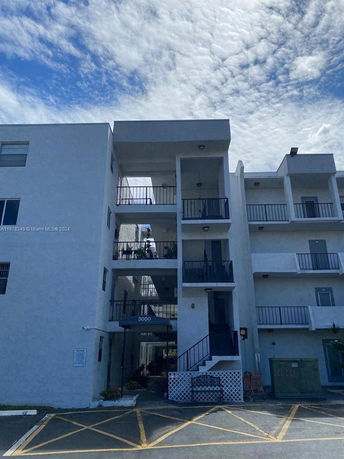 Front view of a multi-story apartment building with balconies.