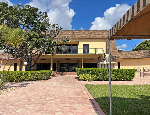 Front view of a two-story building with a large entrance and balcony.