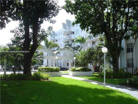 View of residential building with balconies and landscaped garden.