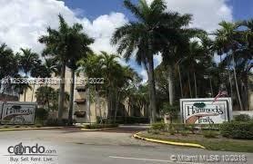 Front view of a multi-story building surrounded by palm trees.