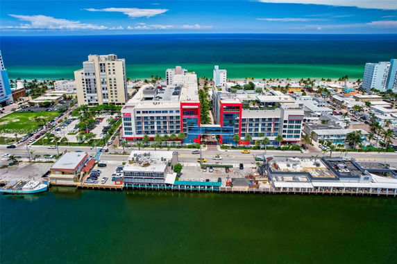 Aerial view of a coastal town with multiple buildings and beachfront.