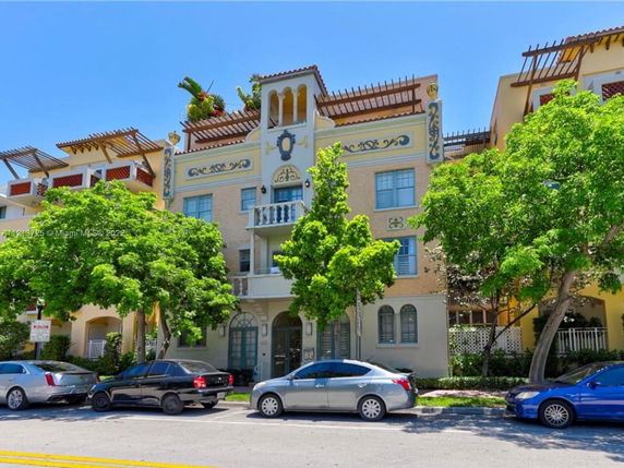 Front view of a multi-story building with decorative architectural elements and balconies.