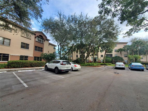 Outdoor parking area in front of a multi-story residential building.