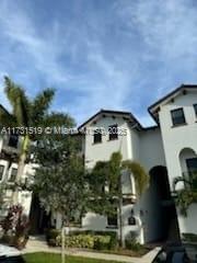 Front view of a multi-story residential building with arched entrances.