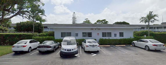 Outdoor parking area in front of a single-story building.