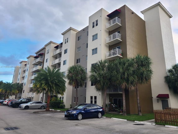 Front view of a multi-story apartment building with balconies.