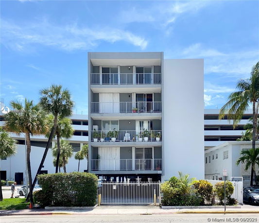Front view of a multi-story apartment building with balconies.
