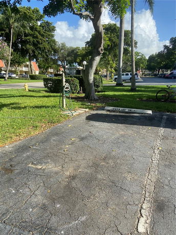 Outdoor parking space with a hose and sign marked 'Carwash Only.'
