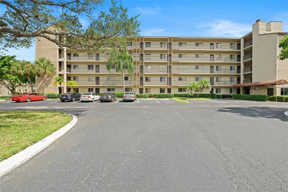 Front view of a multi-story apartment building with balconies.